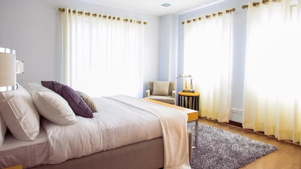 Helles Bett mit weicher, locker über der Bettdecke liegender Decke