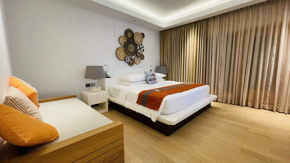 Helles Schlafzimmer mit großem Bett und weißer Bettwäsche